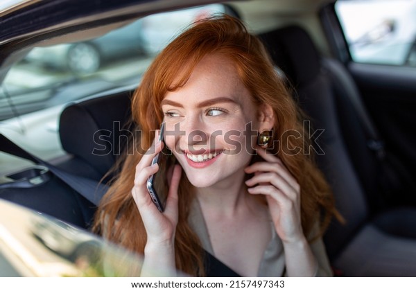 Young girl uses a\
mobile phone in the car. Technology cell phone isolation. Internet\
and social media. Woman with smartphone in her car. Girl is using a\
smartphone in car
