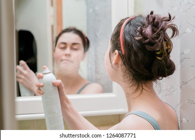 Young Girl Uses Thermal Spray Standing In Front Of Mirror In Bath.