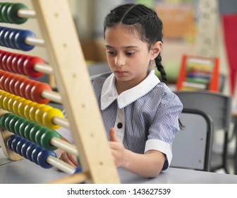 Young girl using abacus in classroom - Powered by Shutterstock