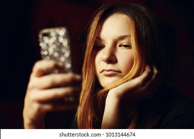 Young girl using a handheld mobile phone texting a message