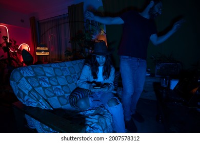 Young Girl Using Mobile Phone At College House Party - Focus On Woman Face