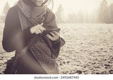 young girl using smartphone outdoor, reflective person texting in the nature vintage effect