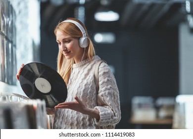 Young Girl With A Vinyl Record In The Music Store