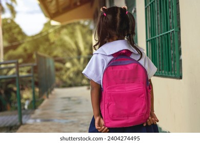 A young girl walking to her classroom. Wearing a pink backpack. At a remote village preschool at the countryside. - Powered by Shutterstock