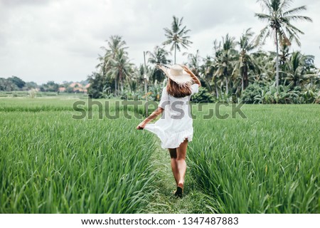 Young girl walking in rice field in Ubud, Bali. Trevelling to clean places of Earth and discovering beauty of nature.