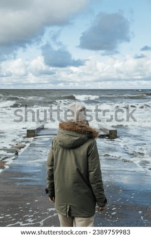 Young girl walks along the shore