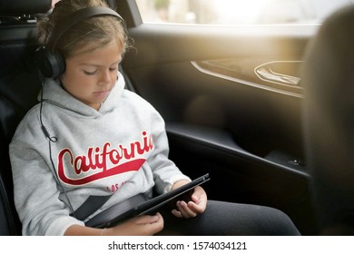 Young Girl Watching Movie While Riding In Car