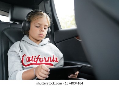 Young Girl Watching Movie While Riding In Car