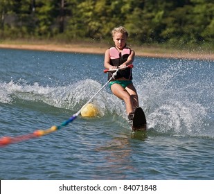 Young girl water skiing on a slalom course.