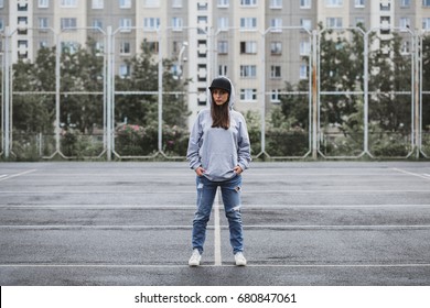 Young girl wearing blank and oversize long hoodie and black cap. Outdoors lifestyle portrait - Powered by Shutterstock