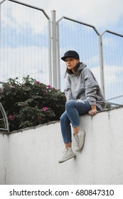 Young Girl Wearing Blank And Oversize Long Hoodie And Black Cap. Outdoors Lifestyle Portrait