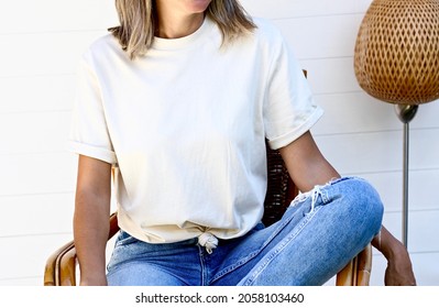 Young girl wearing blank soft cream t shirt. mock up on white wooden background for home boho designs - Shutterstock ID 2058103460