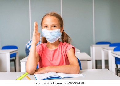 Young girl wearing face mask at school - Multiracial group of kids at primary school - Playful schoolers enjoying school time and lesson with teacher and classmates - Powered by Shutterstock