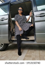 A Young Girl Wearing Polkadot Dress Sitting In A Car