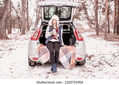 Young Girl Went Out Of Town By Car For A Picnic In Winter. Coffee Break In Winter Park. Pause In Study Outside The City. Out In Nature In Winter 
