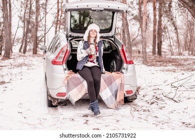 Young Girl Went Out Of Town By Car For A Picnic In Winter. Coffee Break In Winter Park. Pause In Study Outside The City. Out In Nature In Winter 
