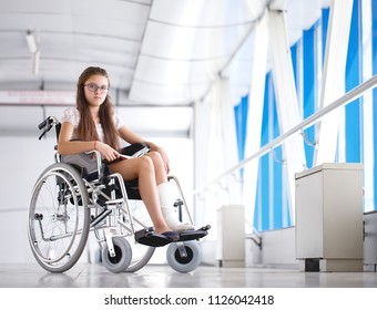 A young girl in a wheelchair is reading a book. Patient in a wheelchair in the hospital corridor. - Powered by Shutterstock