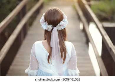 Young girl in white communion dress with a beautiful hairstyle. - Shutterstock ID 2009481362
