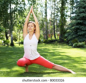 Young Girl In A White Shirt And Red Pants Doing Yoga Outdoors