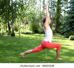 Young Girl In A White Shirt And Red Pants Doing Yoga Outdoors