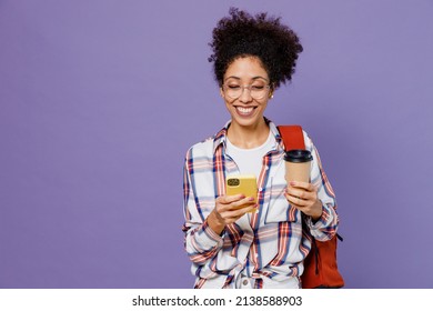 Young Girl Woman Of African American Ethnicity Teen Student In Shirt Backpack Hold Use Mobile Cell Phone Drink Coffee Isolated On Plain Purple Background. Education In High School University Concept