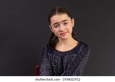 Young Girl In Yearbook Style Portrait Isolated On A Dark Background.