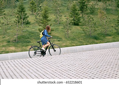 A Young Girl In Zhdinsovom Sarafan On A Bicycle, Climbs Uphill. Bike Tours In The City