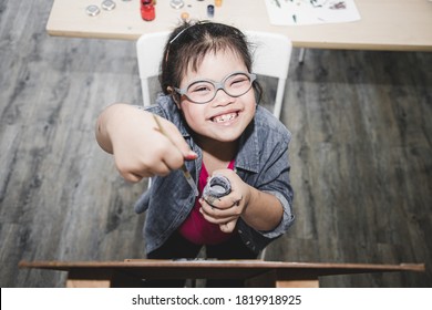 Young Girls Disabilities Or Down's Syndrome Learning About Painting Watercolor And Bright Smile For Active Learning And Encouraging Beside. Education And Special Child Concept.