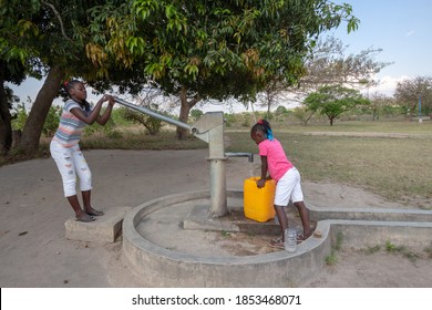  Young Girls Getting Fresh Water In The Community Hand Water Pump In Rural Africa