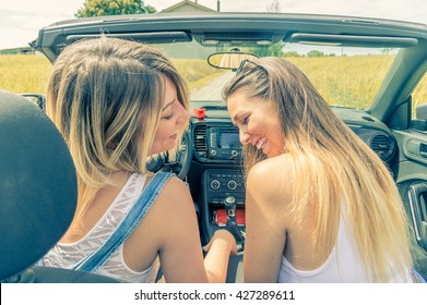 Young girls having fun at car trip - Two caucasian friends smiling outdoor in a summertime - Main focus on them 