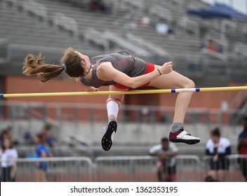 Young Girls Jumping High In The Air During A High Jump Track Meet