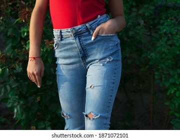 Young girl's legs in blue torn jeans.