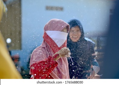 Young Girls Playing Breaking The Water Balloon With Blindfold