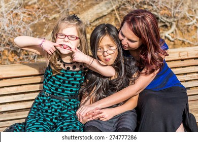 Young girls playing with their mother at a park in Reno, Nevada, USA.