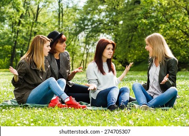 Young Girls Are Sitting In The Park And Arguing Because Of Something.Conflicts Between Friends