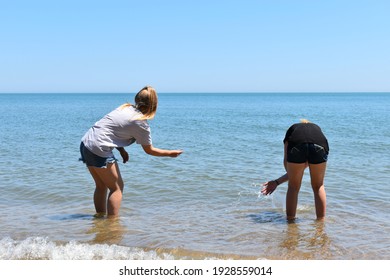 Young Girls Skipping Rocks In Lake Michigan