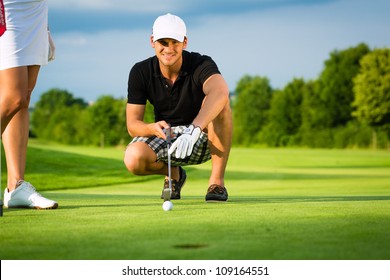 Young golf player on course putting, he aiming for his put shot - Powered by Shutterstock