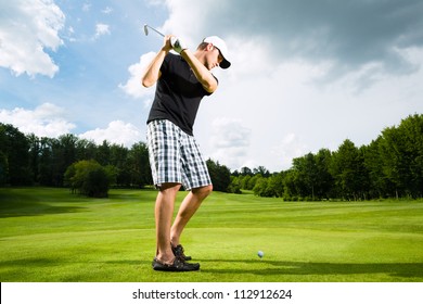 Young Golf Player On Course Doing Golf Swing, He Presumably Does Exercise