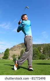 Young Golfer Hitting A Shot With An Iron