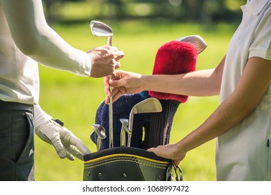 Young Golfer Man Select Club From Bag With His Caddy