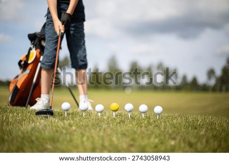 Young Golfer Training with Multiple Golf Balls on Tee, Skill Development Concept
