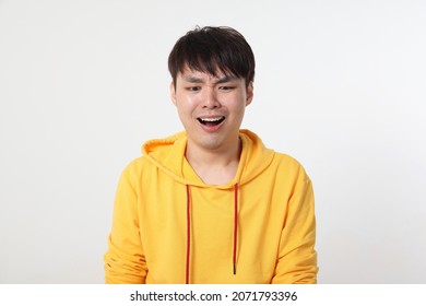 Young good looking Asian chinese man pose face body expression mode emotion on white background sad shocked mouth open look down