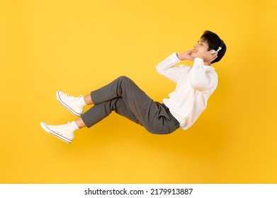 Young good looking asian man floating while listen with headphone isolated on yellow background - Shutterstock ID 2179913887