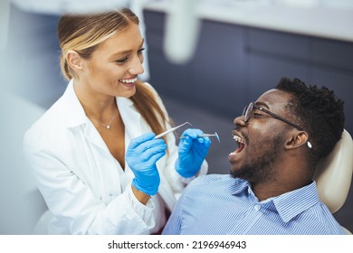 Young Good Looking Man Having Dental Treatment At Dentist's Office. African Guy In Dentist Chair Looking With Trust At His Doctor, Close Up. Man Having Teeth Examined At Dentists. 