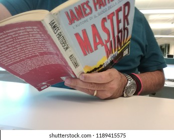 Young Good Looking Man Reads James Patterson Master Mind Book In Milan, Italy-September 2018