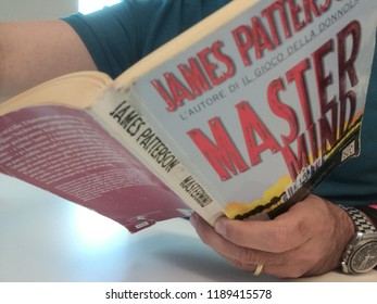 Young Good Looking Man Reads James Patterson Master Mind Book In Milan, Italy-September 2018