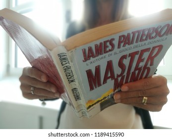 Young Good Looking Woman Reads James Patterson Master Mind Book In Milan, Italy-September 2018