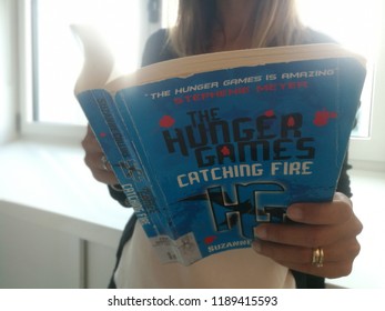 Young Good Looking Woman Reads Stephenie Morgan Meyer Hunger Games Series Book In Milan, Italy-September 2018