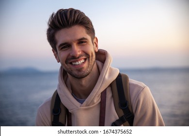 Young good-looking chap is smiling with a gorgeous sunset view  - Shutterstock ID 1674375652