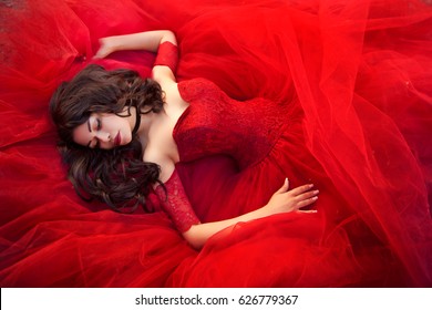 Young Gorgeous Dreamy Woman Lying In Red Dress 